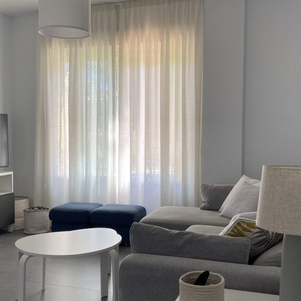 reforma vivienda gaditana puerto de santa maría cádiz segado arquitectos diseño interior tonos neutros luz espacio salón sofá televisión gris