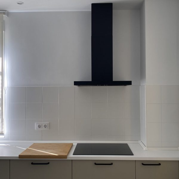 reforma vivienda gaditana puerto de santa maría cádiz segado arquitectos diseño interior tonos neutros luz espacio cocina detalle fogones ventana madera blanco